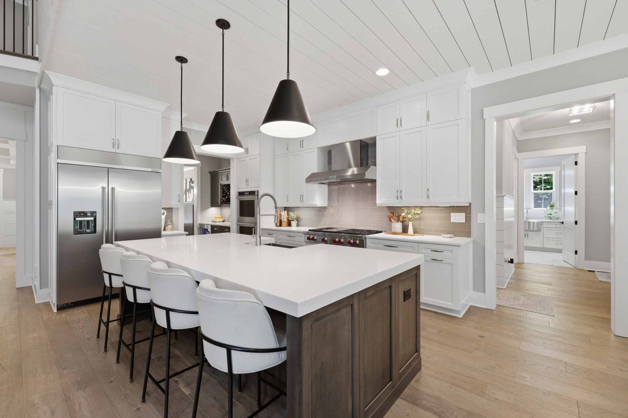 Silver Falls kitchen with white cabinetry, warm wood island, and black pendants